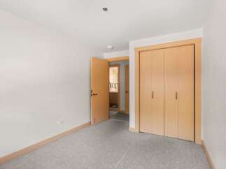 Step into this inviting room featuring a spacious closet with light wood doors, perfect for ample storage.