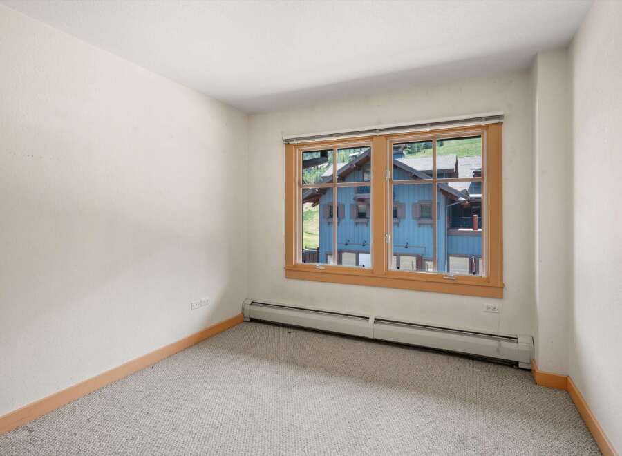 This room features a large window offering picturesque views of the surrounding mountain landscape and charming blue architecture.