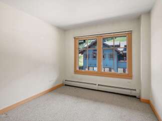 This room features a large window offering picturesque views of the surrounding mountain landscape and charming blue architecture.