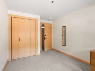 This bedroom features a spacious closet with double doors and a sleek, modern design.