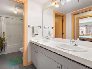 This modern bathroom features a double vanity with sleek chrome fixtures and ample counter space.