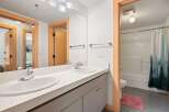 This bright and airy bathroom features a spacious double vanity with modern chrome fixtures, perfect for busy mornings.