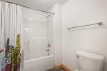 This bathroom features a clean white bathtub and shower combo, complemented by a stylish shower curtain with a cactus print.