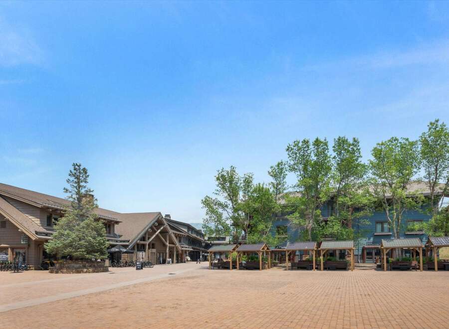 Discover this charming mountain village square, featuring a mix of rustic lodge-style architecture and modern amenities.