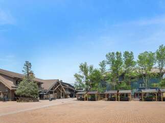 Discover this charming mountain village square, featuring a mix of rustic lodge-style architecture and modern amenities.