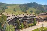 Experience luxury mountain living in this stunning property, featuring a grand lodge-style building with multiple balconies and expansive windows.