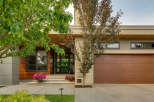 Discover modern luxury with this stunning home featuring a striking facade of wood, stone, and stucco.