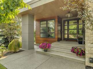 Experience modern luxury with this stunning home featuring a sleek facade of wood and stone accents.