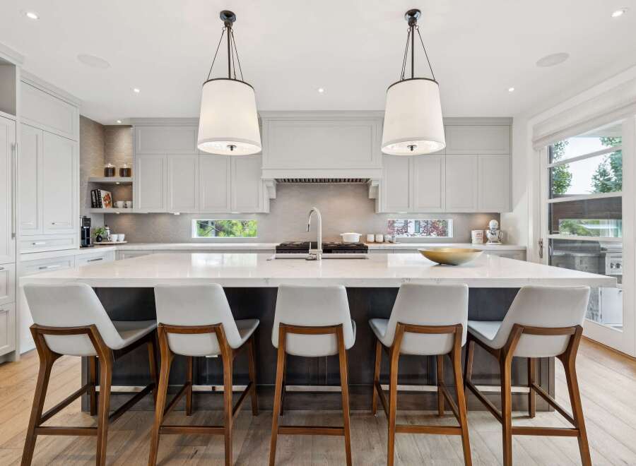 Experience luxury in this stunning modern kitchen, featuring a spacious waterfall island with ample seating.