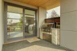 Experience seamless indoor-outdoor living with this modern covered patio, featuring a sleek sliding glass door that opens to a gourmet outdoor kitchen.