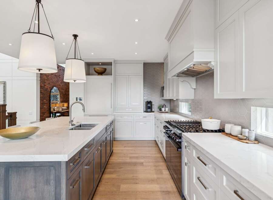 Experience luxury in this stunning modern kitchen, featuring a spacious island with a double sink and elegant pendant lighting.