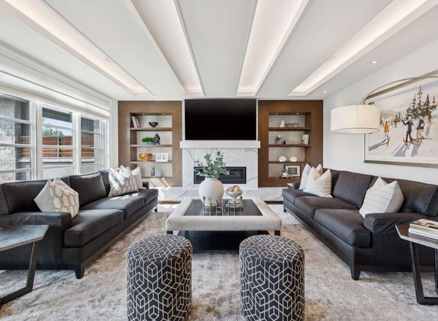 Experience luxury living in this impeccably designed living room, featuring a stunning marble fireplace and a large flat-screen TV.