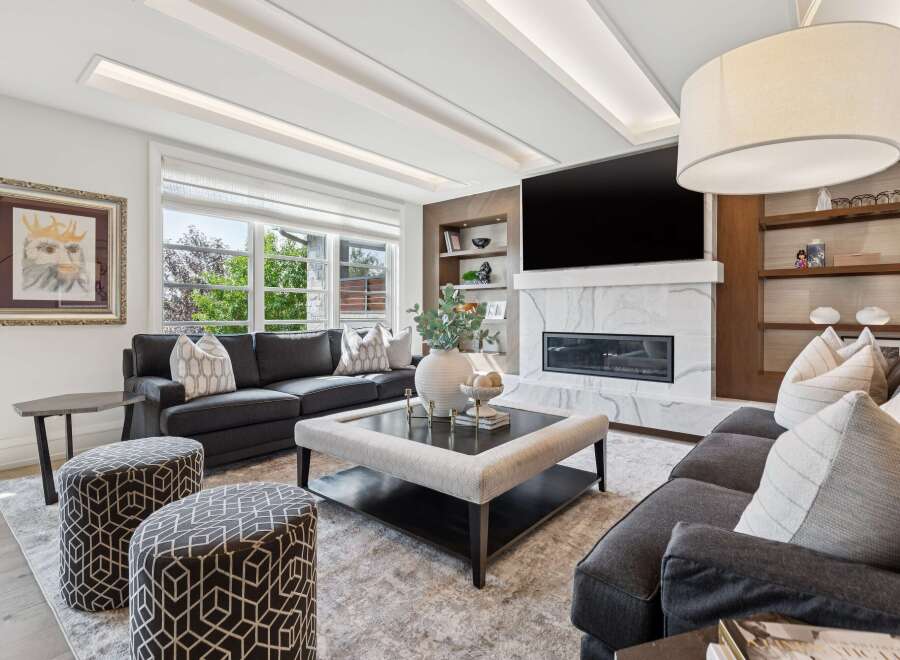 Experience luxury living in this stunning modern living room, featuring a sleek fireplace, a large flat-screen TV, and elegant built-in shelving.