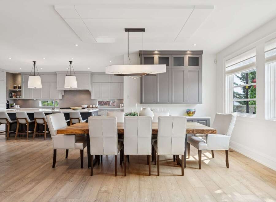 Experience elegant open-concept living with this stunning dining area seamlessly connected to a modern kitchen.