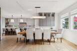 Experience elegant open-concept living with this stunning dining area seamlessly connected to a modern kitchen.