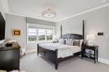 Experience luxury in this master suite featuring a grand four-poster bed adorned with plush pillows and a crisp white duvet.