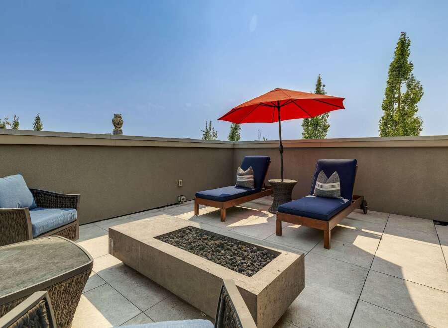Enjoy outdoor living at its finest on this spacious rooftop patio, complete with a modern fire pit and comfortable lounge seating.