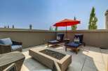 Enjoy outdoor living at its finest on this spacious rooftop patio, complete with a modern fire pit and comfortable lounge seating.