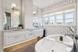 Indulge in luxury with this stunning bathroom featuring a spacious soaking tub and elegant vanity.