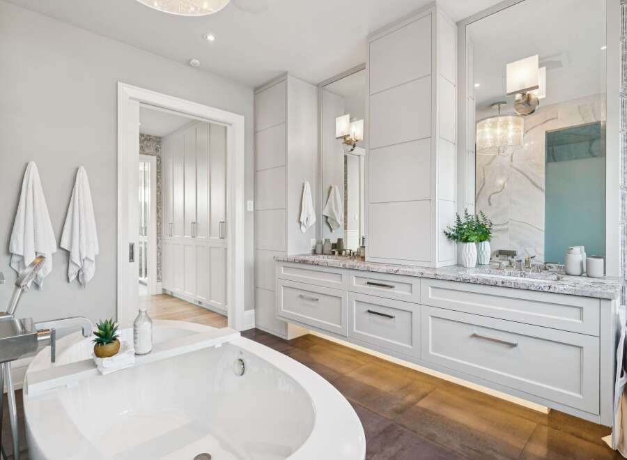 Indulge in luxury with this stunning master bathroom, featuring a freestanding soaking tub and a spacious double vanity with elegant marble countertops.