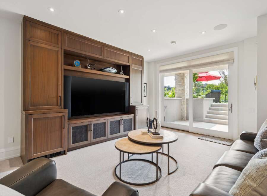 This inviting living room features a custom built-in entertainment center with ample storage and display space, perfect for showcasing decor.
