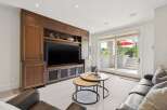 This inviting living room features a custom built-in entertainment center with ample storage and display space, perfect for showcasing decor.