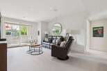 Step into this inviting living space featuring a plush leather sofa and a comfortable recliner, perfect for relaxation.
