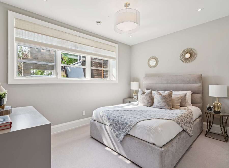 Experience luxury and comfort in this beautifully appointed bedroom, featuring a plush king-sized bed with a striking upholstered headboard.