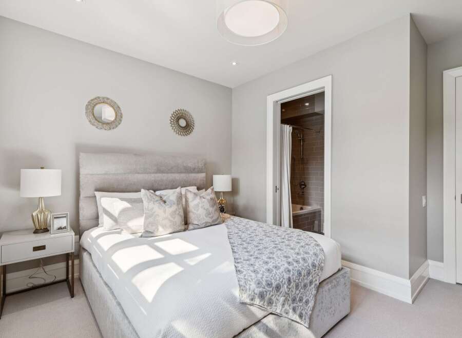 Experience luxurious comfort in this elegantly appointed bedroom, featuring a plush upholstered headboard and a beautifully patterned throw.