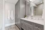 Experience modern elegance in this beautifully appointed bathroom, featuring a sleek grey vanity with ample storage and a pristine white countertop.