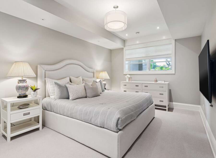 Experience serene comfort in this elegantly appointed bedroom, featuring a plush king-sized bed with a sophisticated upholstered headboard.