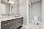 Experience modern luxury in this stunning bathroom featuring a sleek vanity with ample storage and a pristine white countertop.