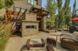 Experience luxurious outdoor living with this stunning patio featuring a modern stone fireplace and a beautiful wooden pergola.