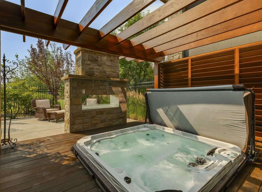Experience ultimate relaxation in this luxurious backyard oasis, featuring a bubbling hot tub perfect for unwinding.