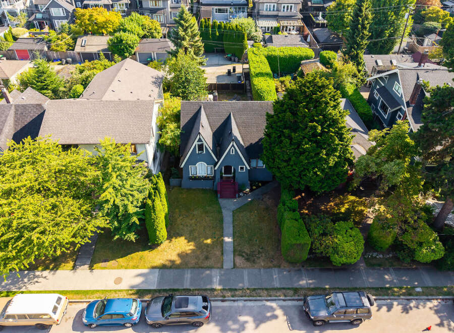 Discover this charming home featuring a distinctive dark blue exterior with a classic gabled roofline and inviting red-accented steps leading to the entrance.
