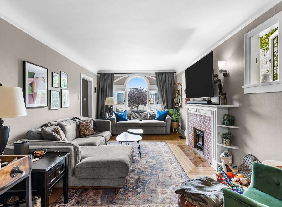 Step into this inviting living room, featuring a spacious sectional sofa perfect for gatherings and a cozy fireplace for chilly evenings.