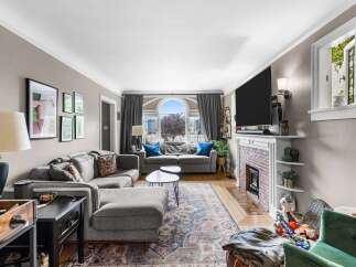 Step into this inviting living room, featuring a spacious sectional sofa perfect for gatherings and a cozy fireplace for chilly evenings.