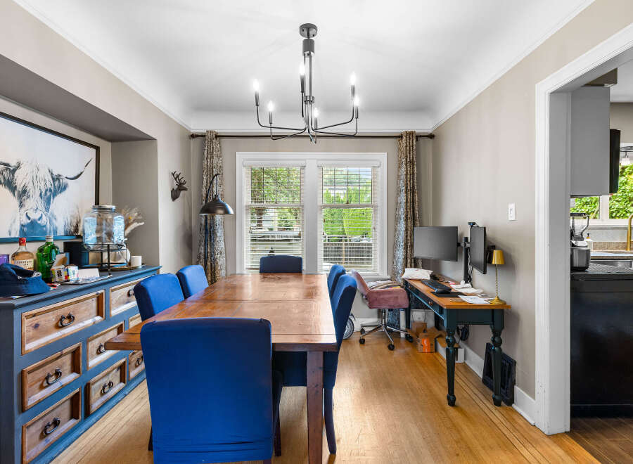 This dining room features a large wooden table surrounded by vibrant blue upholstered chairs, perfect for family gatherings.