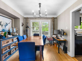 This dining room features a large wooden table surrounded by vibrant blue upholstered chairs, perfect for family gatherings.