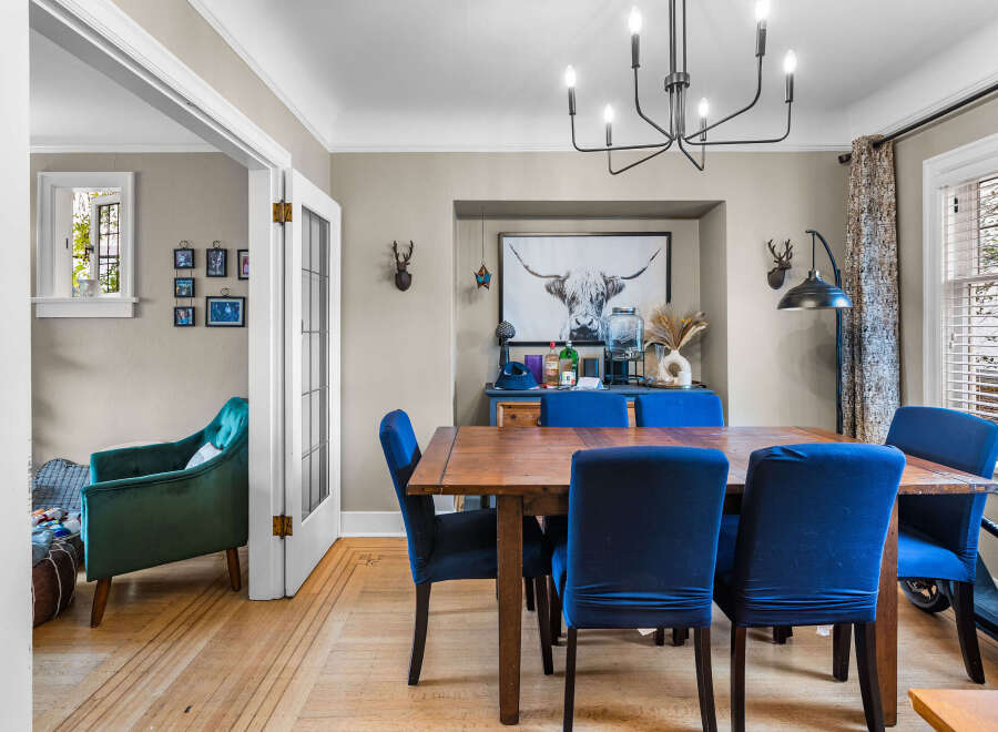 Step into this charming dining room, featuring a rustic wooden table surrounded by plush blue chairs, perfect for intimate gatherings.