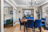Step into this charming dining room, featuring a rustic wooden table surrounded by plush blue chairs, perfect for intimate gatherings.