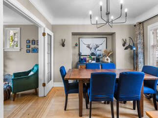 Step into this charming dining room, featuring a rustic wooden table surrounded by plush blue chairs, perfect for intimate gatherings.