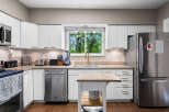 Discover this beautifully updated kitchen featuring sleek white cabinetry and modern stainless steel appliances.