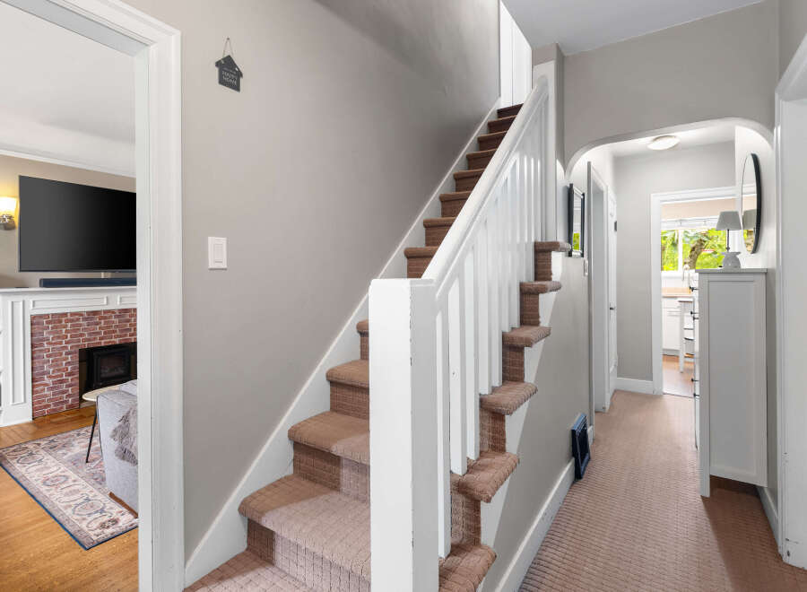 Step into this charming home featuring a cozy living area with a brick fireplace and a large television, perfect for relaxing evenings.