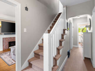 Step into this charming home featuring a cozy living area with a brick fireplace and a large television, perfect for relaxing evenings.