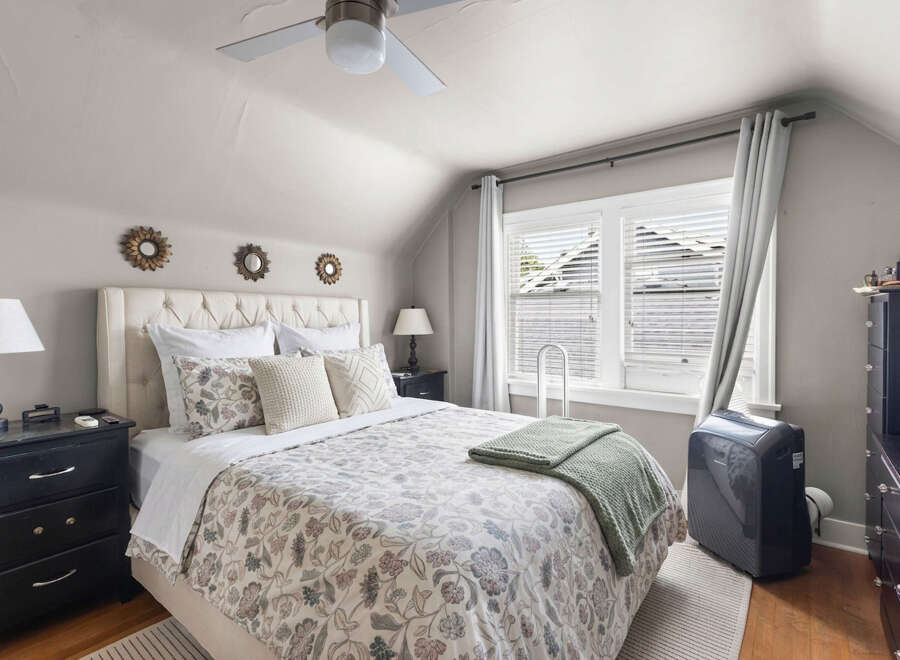 Discover this charming bedroom featuring a plush tufted headboard and a beautifully patterned duvet.