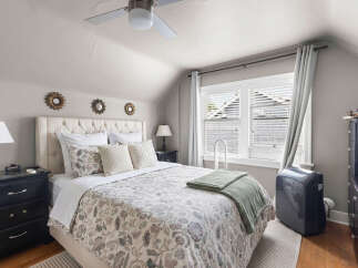 Discover this charming bedroom featuring a plush tufted headboard and a beautifully patterned duvet.