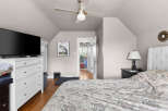 Discover this charming bedroom featuring a comfortable bed with a tufted headboard, perfect for relaxation.