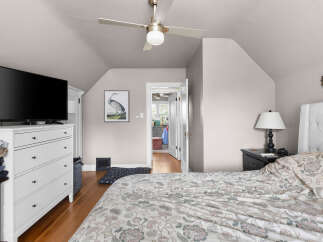 Discover this charming bedroom featuring a comfortable bed with a tufted headboard, perfect for relaxation.