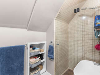 Discover this charming bathroom featuring a spacious tiled shower with a glass enclosure and a modern showerhead.
